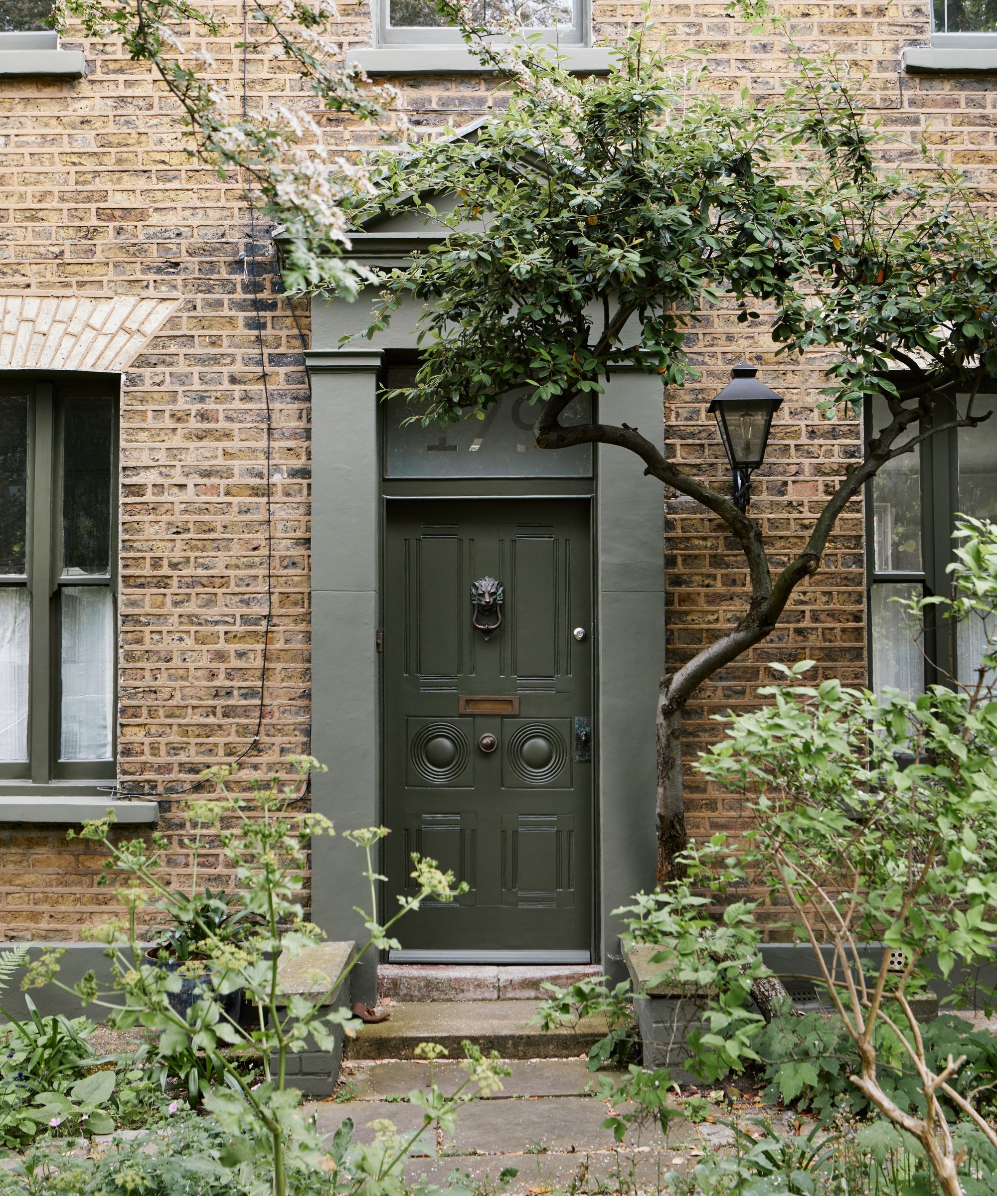 A red brick house with a dark green front door