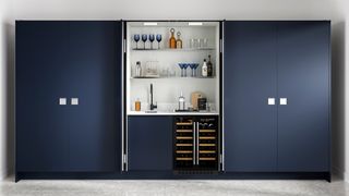 Navy blue kitchen cabinets with pocket doors to conceal a home bar