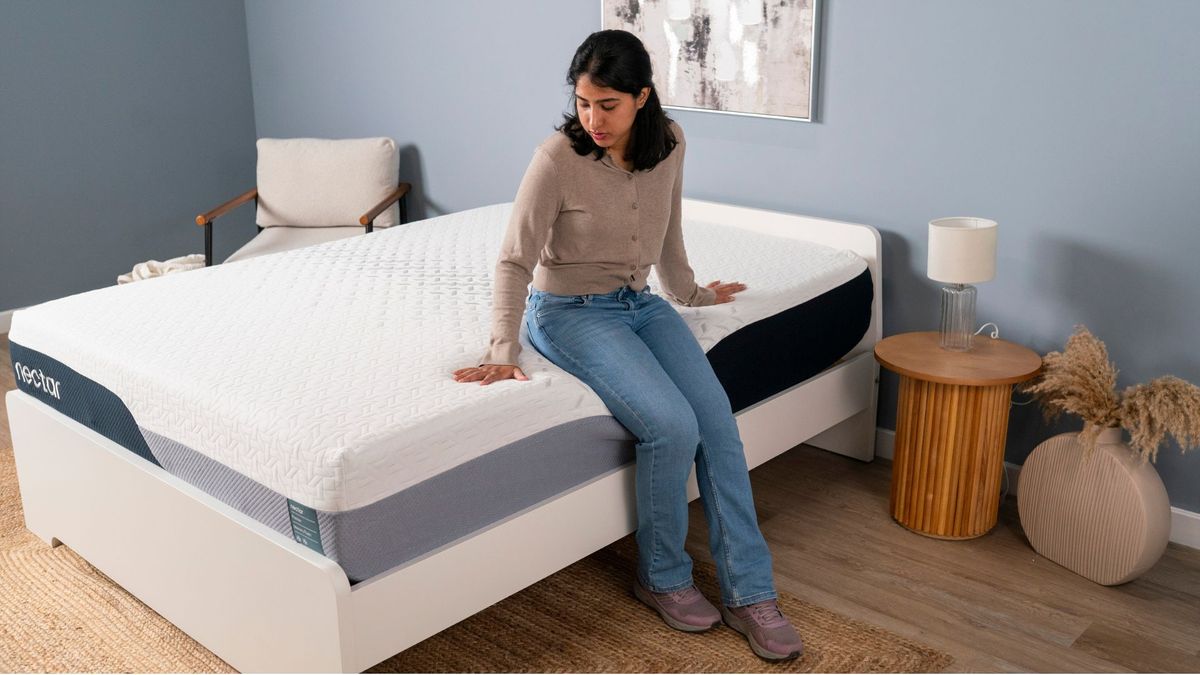Tester Becky George sits on the side of the Nectar Premier Memory Foam Mattress to test its edge support.