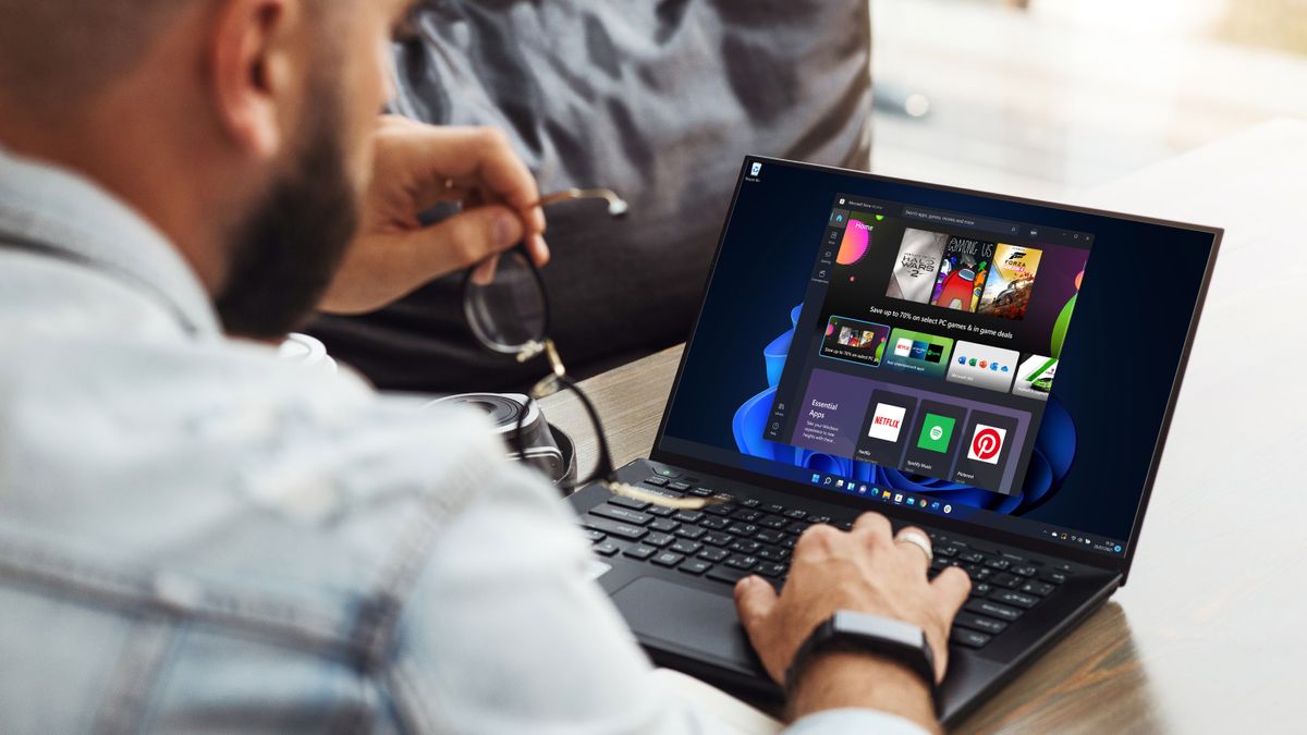 Back view of a man using a laptop with Windows 11&#039;s Microsoft Store app open