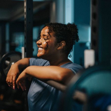 How to structure your weights sessions: a woman stood by a barbell at a gym mid-workout