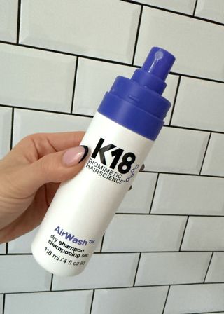 A handheld view of the K18 AirWash Dry Shampoo without its lid