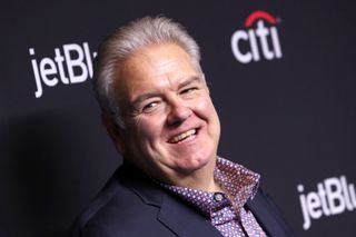 jim o'heir from parks and recreation smiling on a red carpet