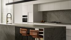 A kitchen with a stone island, with a linear light above the counter