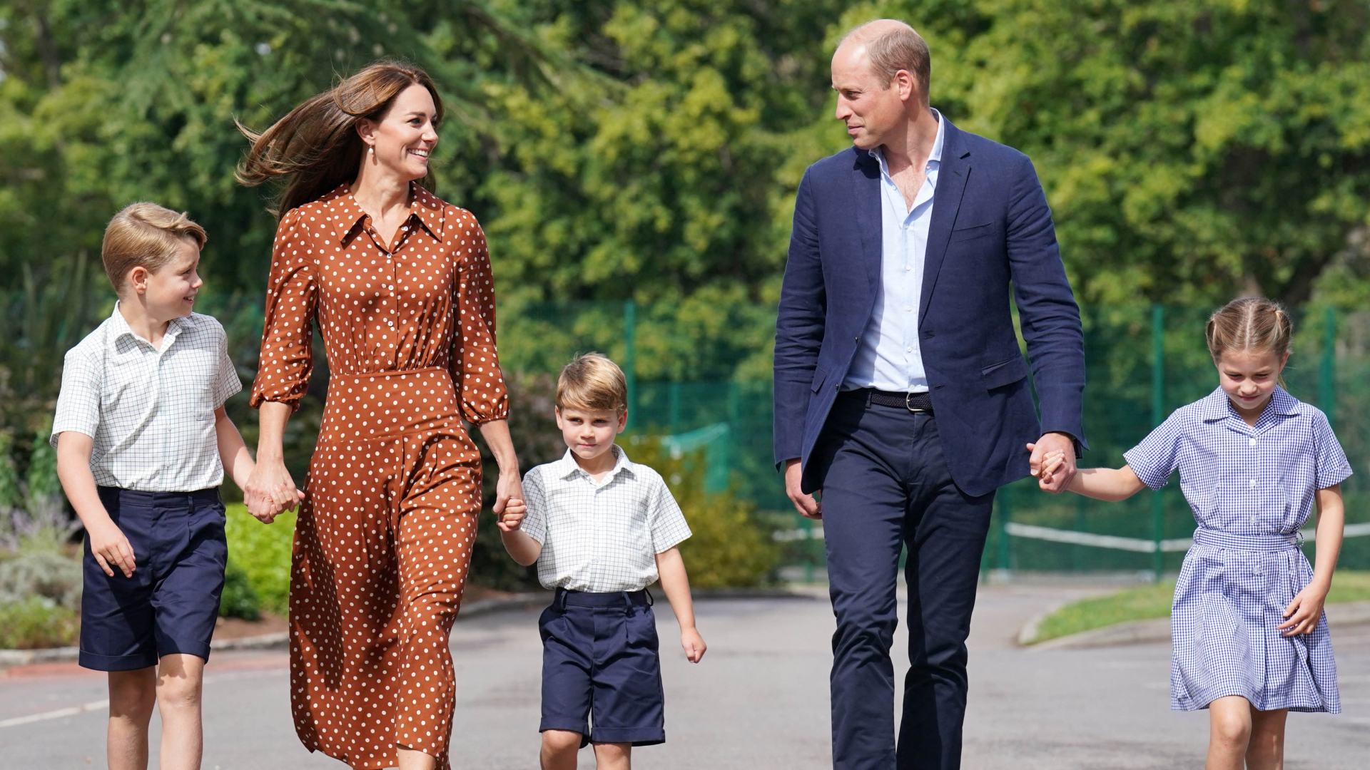 Prince George, Kate Middleton, Prince Louis and Princess Charlotte holding hands in a line with their parents walking to school