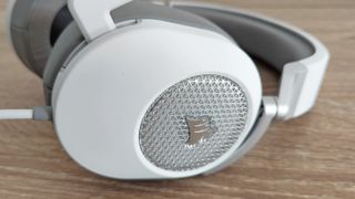 Corsair HS65 Surround review: close up of gaming headset earcup in white and silver