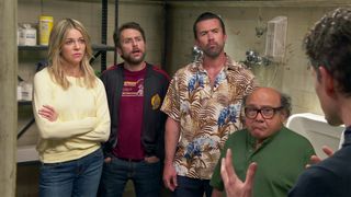Dee (Kaitlin Olson), Charlie (Charlie Day), Mac (Rob McElhenney) and Frank (Danny DeVito) looking at Dennis (Glenn Howerton) almost off camera in a still from It's Always Sunny In Philadelphia season 15
