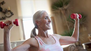 Woman holding up dumbbells doing shoulder press