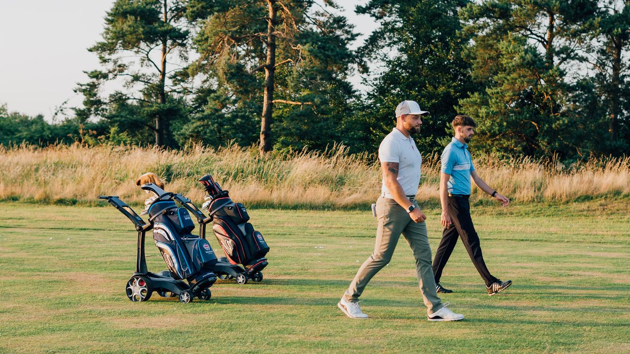 Two golfers using the Stewart Golf Q Follow trolley