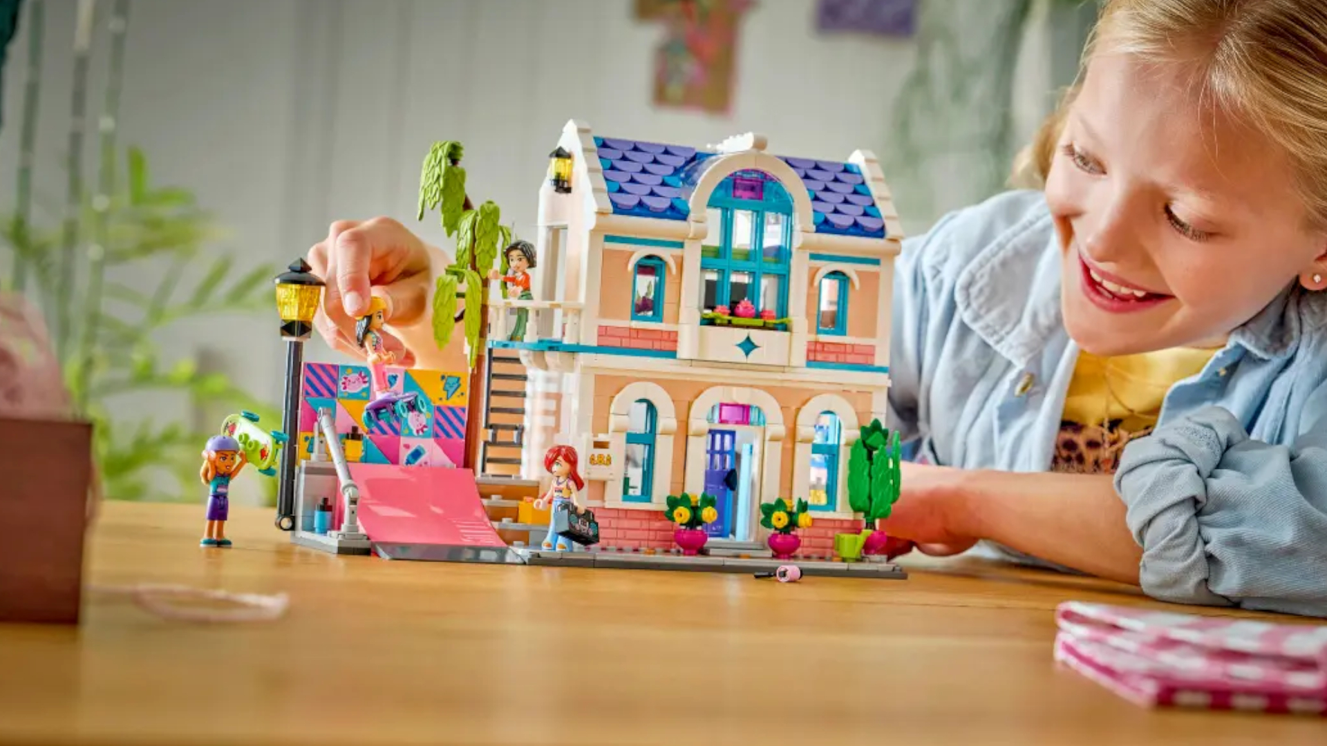 A child plays with a Lego house and skate park set