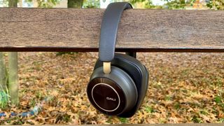 Dali iO-12 headphones on a park bench with autumnal leaves