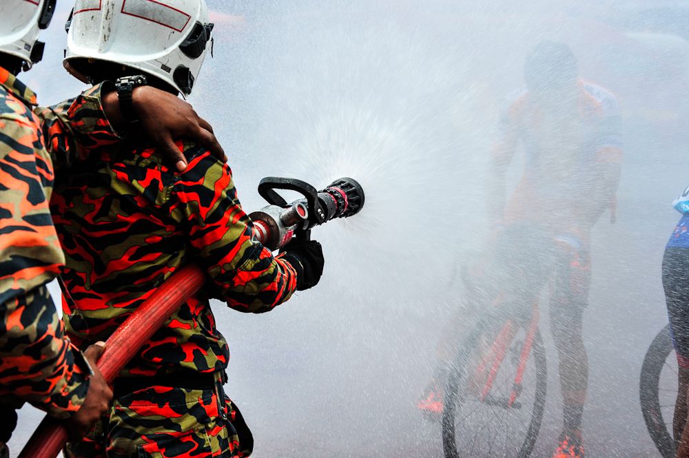 A fireman hoses down the over-heated riders at the 2017 Tour de Langkawi