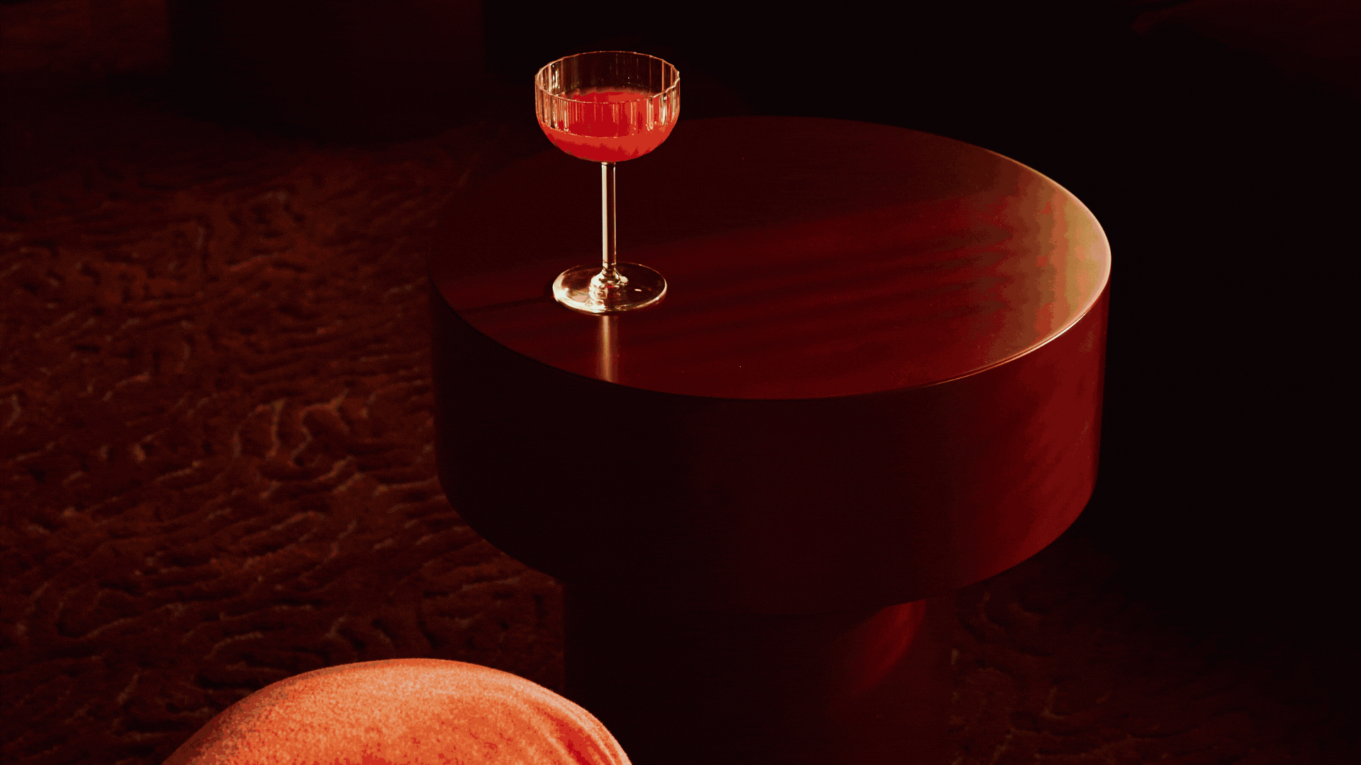 A gif shows a series of interiors, including a moody red bar, an industrial installation with sculptures, a crowd dancing in a club, a naturally lit wooden table with flowers, and a black wooden one.