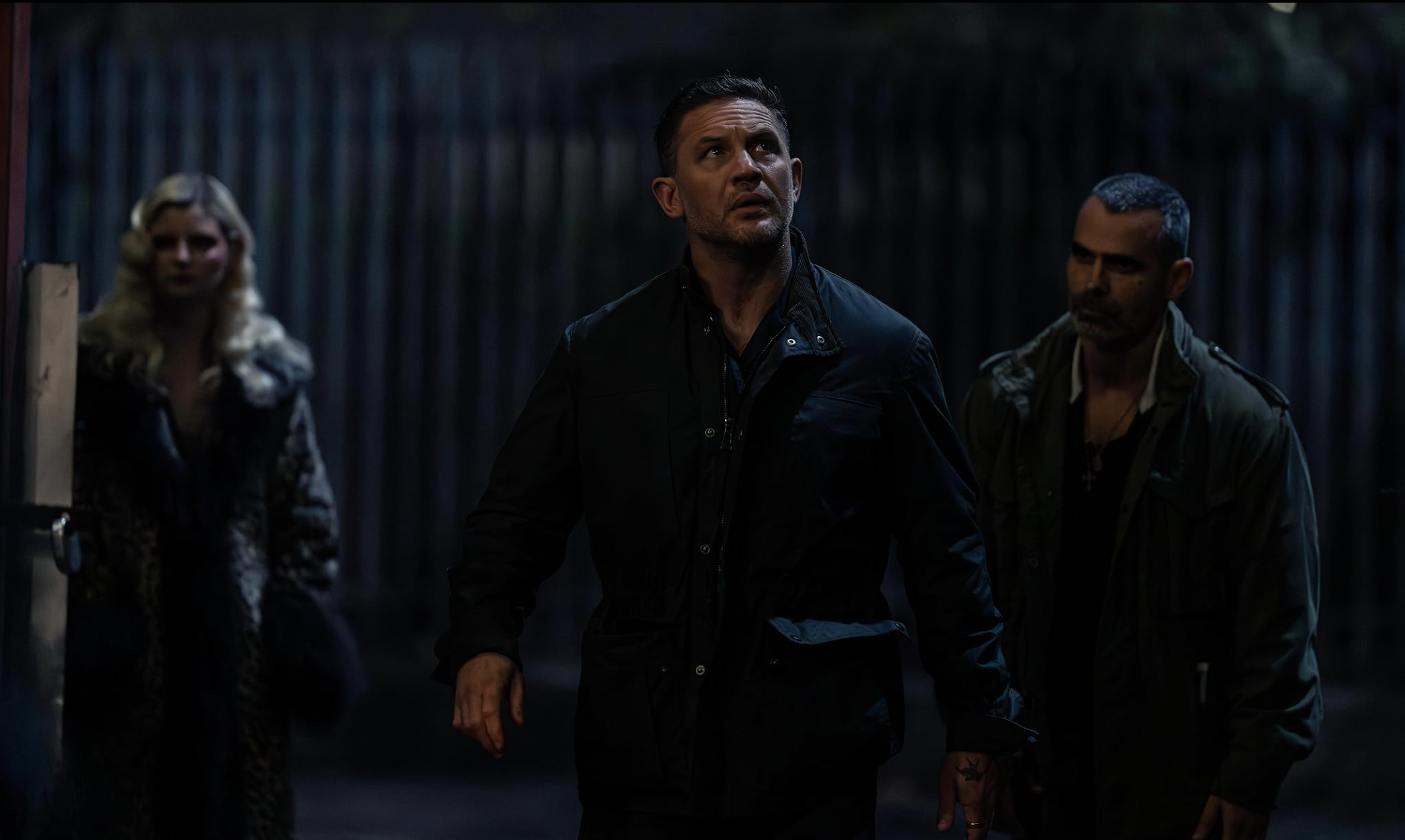an image of Tom Hardy being suitably boss and moody striding into some kind of warehouse in MobLand S2