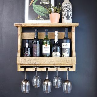 dark blue wall with wooden shelf pallet with drink bottles and glass hanging