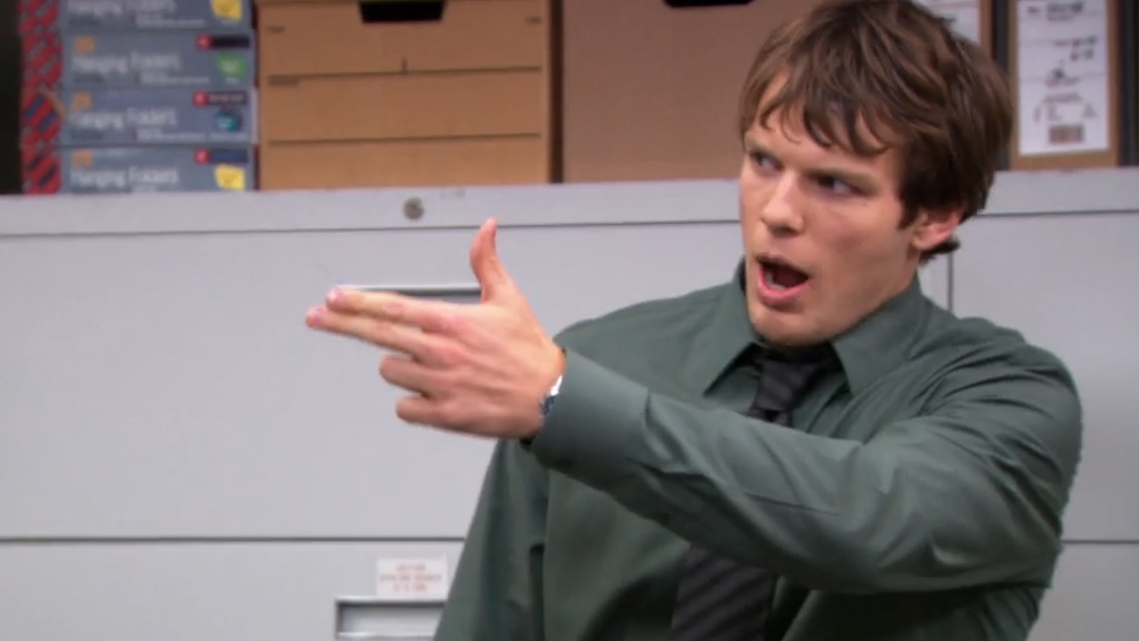 Jake Lacy as Pete doing a gun gesture with his fingers in The Office