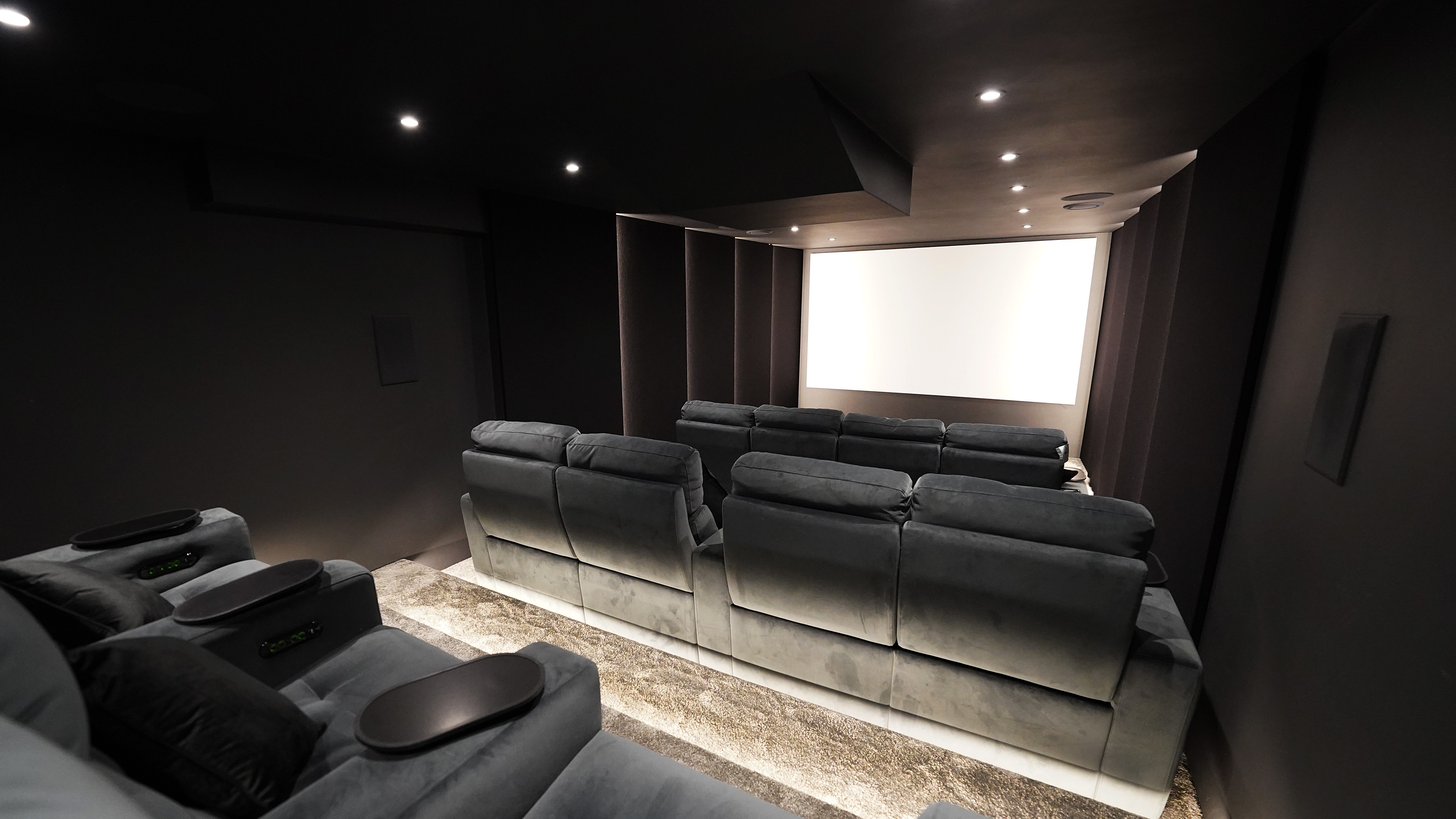 Home theater space showing comfortable seating and wide projection screen