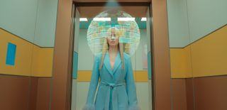 Lindy Pepper-Bean (Callie Cooke) steps into an elevator that's decorated in a lot of pastel shades. She has a virtual 'bubble' encircling her head, which contains lots of windows from her app.