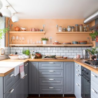Kitchen with orange walls, white metro tiles and grey cabinets