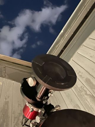 The flat telescope lens attached to a telescope on a building.