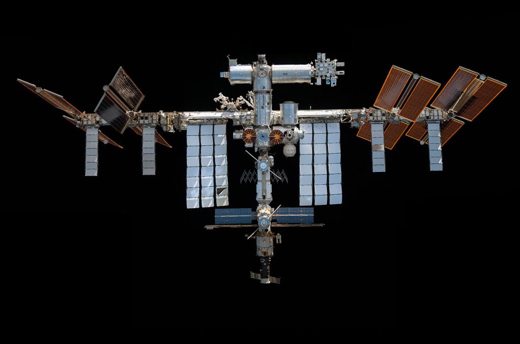 Photograph of the ISS against the black backdrop of space.