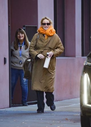 jennifer lawrence wears a $6,025 coat with an orange scarf