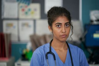 Priyanka Patel as Dr Ramya Morgan wearing a stethoscope and blue scrubs