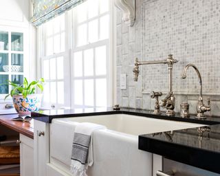 A bright, traditional kitchen with an enamel kitchen sink and window seat