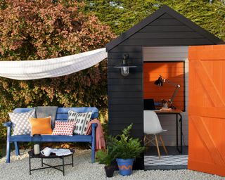 painted shed used as a home office with a seating area outside