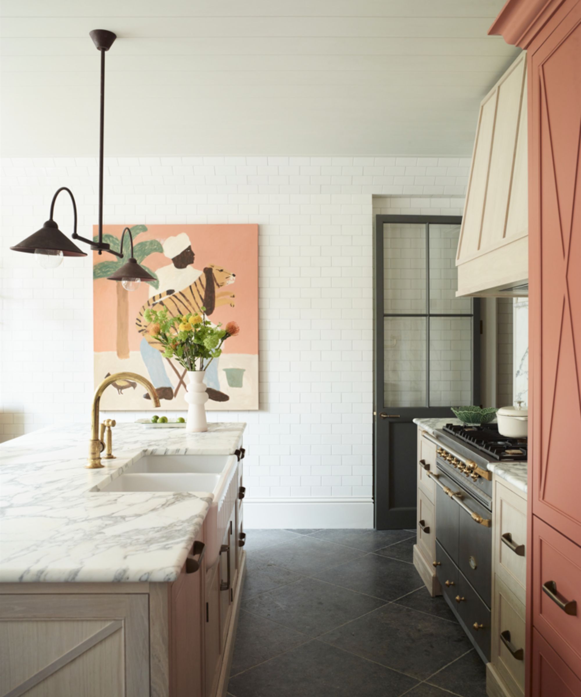 Marble, cream and peach colored kitchen with art on wall