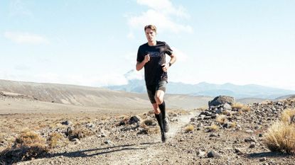 Benefits of compression shorts: pictured here a man running in an arid environment wearing compression shorts and socks