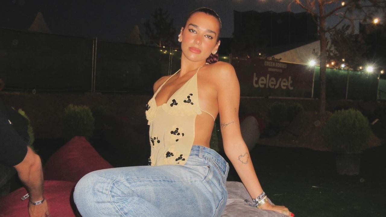 Dua Lipa wearing a sheer halter top with baggy jeans and red Puma Speedcat sneakers at the Sunny Hill Festival July 2024