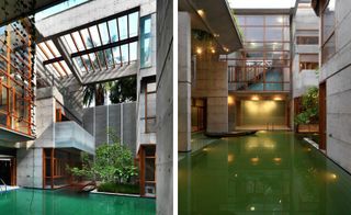 A modern house with a large green pool, concrete walls, and terraces, and wood elements for decking and doors.