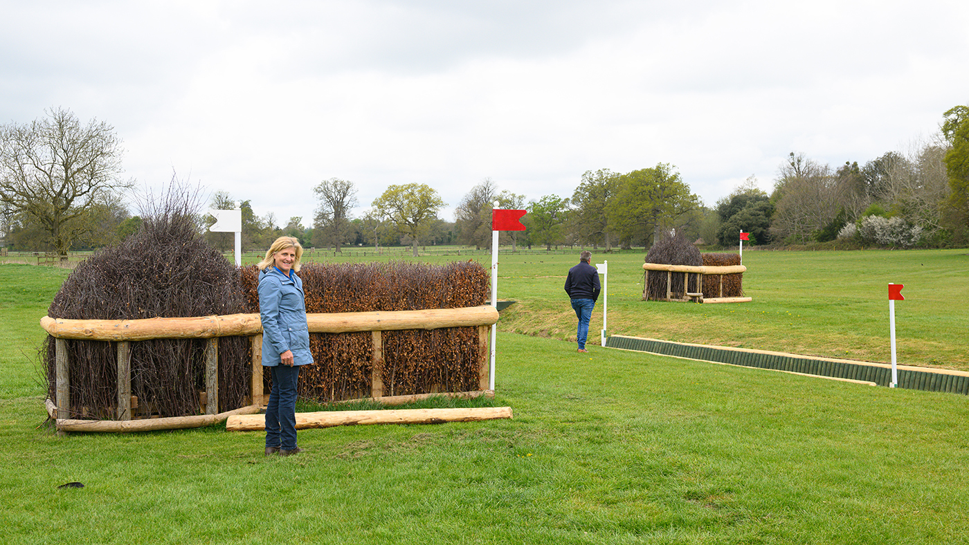 Tina Cook stands in front of the first element of fence 19abc: Lemieux Eyelash Brushes on the Badminton Horse Trials cross-country course 2025.
