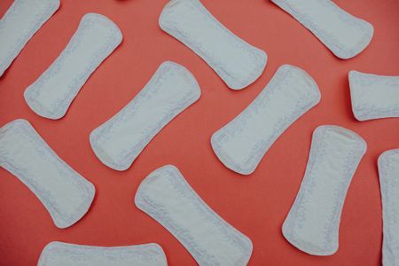 Heavy periods: Some sanitary pads on a red background