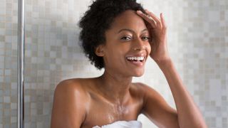 Lady with afro hair in shower smiling