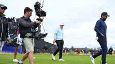 A TV cameraman films US golfer Jordan Spieth (C) as he leaves the 17th green on day two of the 151st British Open Golf Championship at Royal Liverpool Golf Course in Hoylake, north west England on July 21, 2023. The 151st Open at The Royal Liverpool Golf Course is set to run until July 23. 