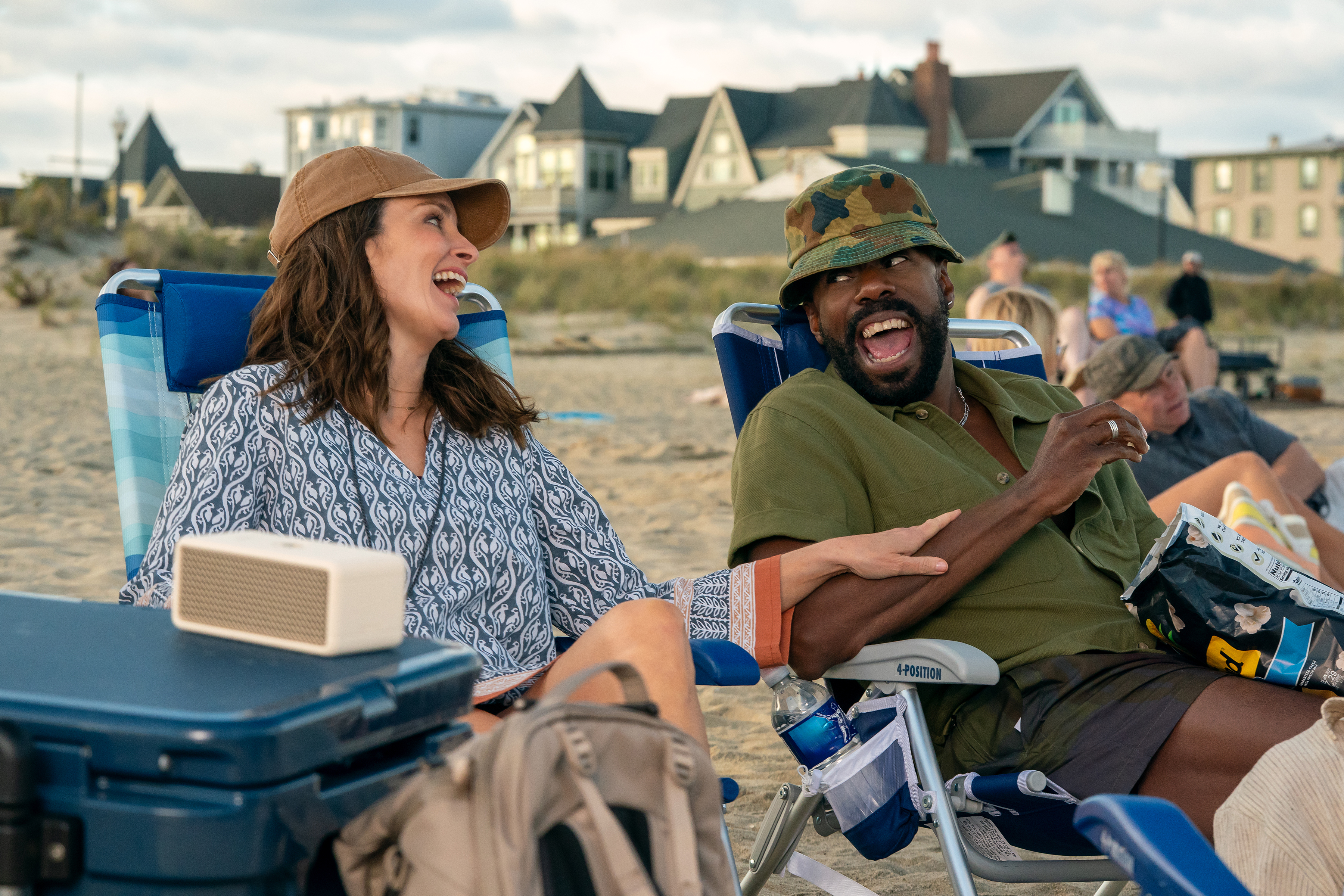 Tina Fey as Kate and Colman Domingo as Danny laughing in lawn chairs on a beach in the four seasons season 2