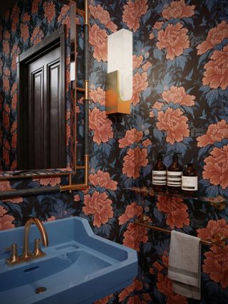 bold floral wallpaper and blue colourful sink in powder room by Divine Savages