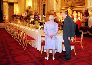 Queen Elizabeth II inspecting state banquet table
