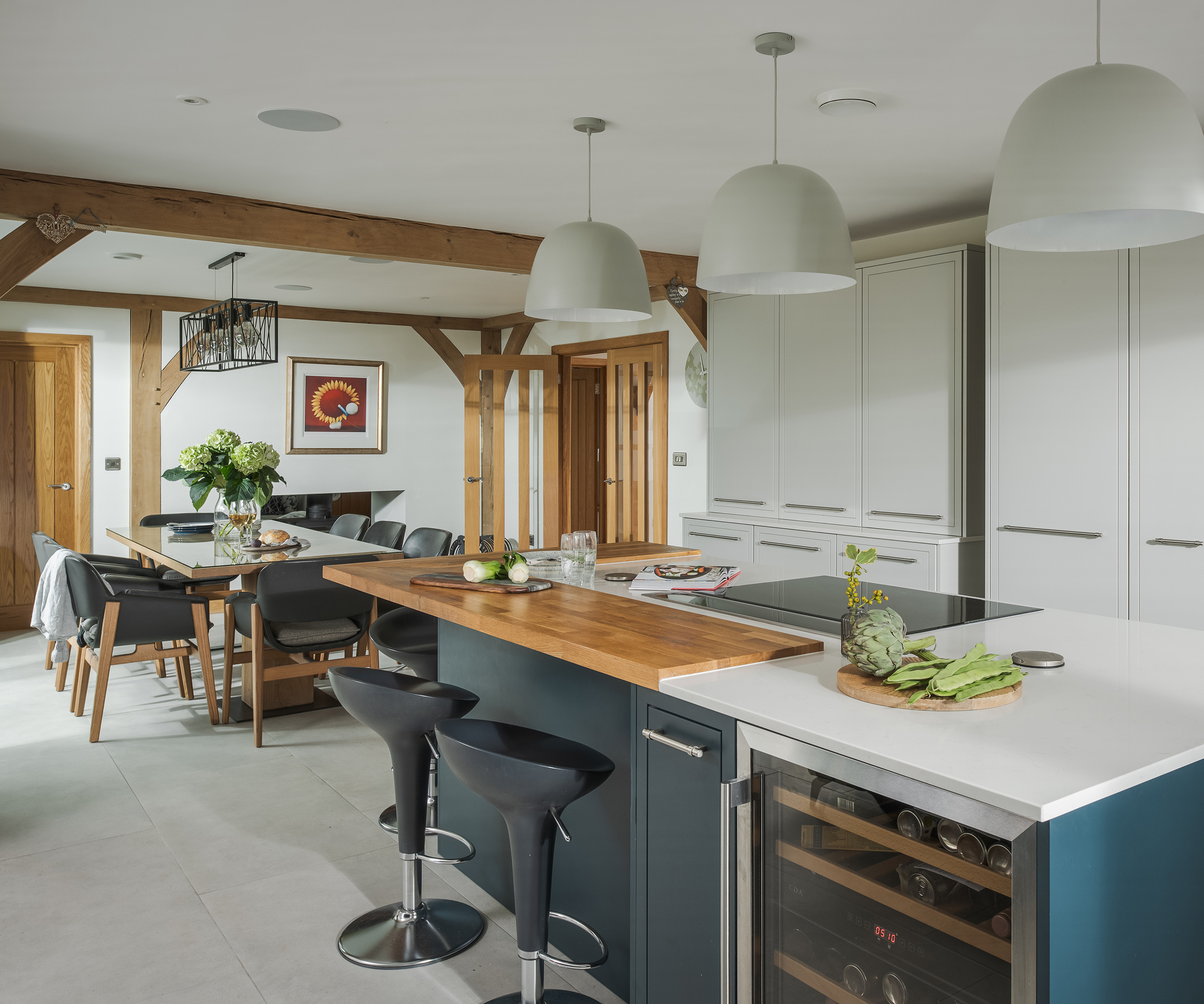 An open plan kitchen/diner in a self build home with exposed oak beams