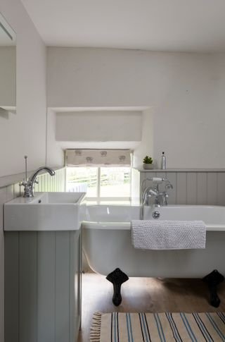 freedstanding bath with sink and blinds in grey bathroom