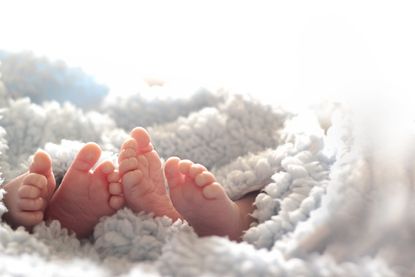 A close-up of two baby twins and their toes