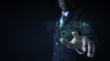 A man pointing to a graphic with the infinity symbol and some icons representing the circular economy