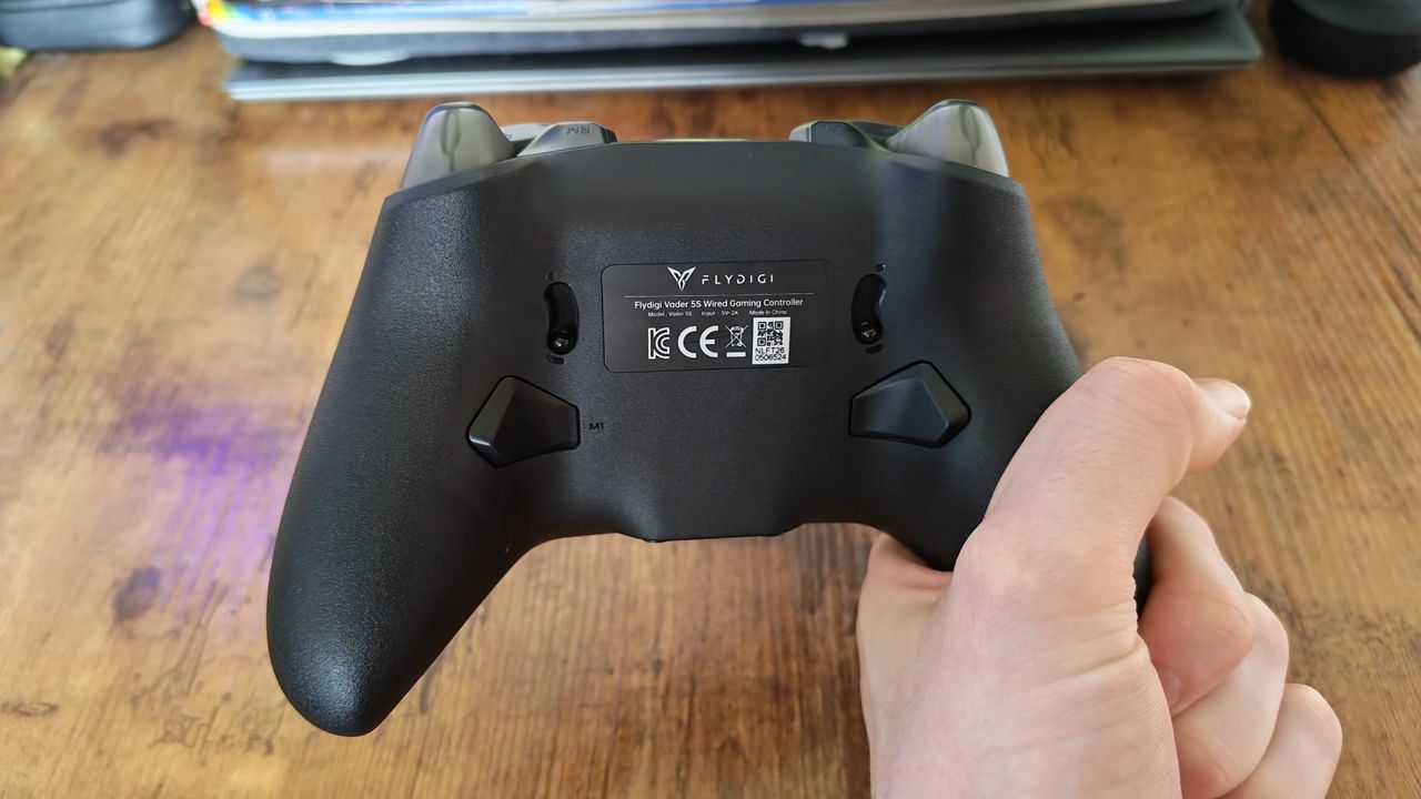 A reviewer showcasing the back of the Flydigi Vader 5S