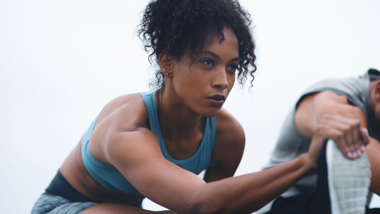 How to improve your fitness fast: A woman stretching her leg