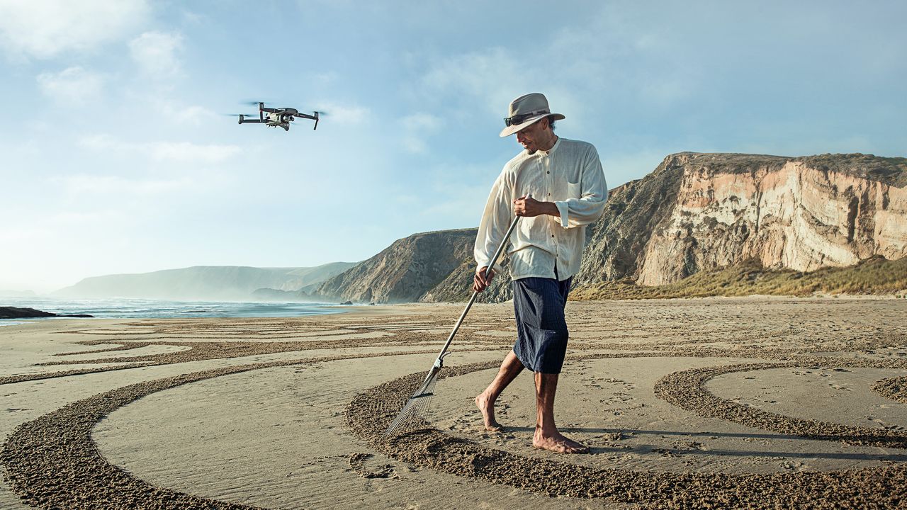 Man on beach with DJI Mavic 2 Zoom flying above