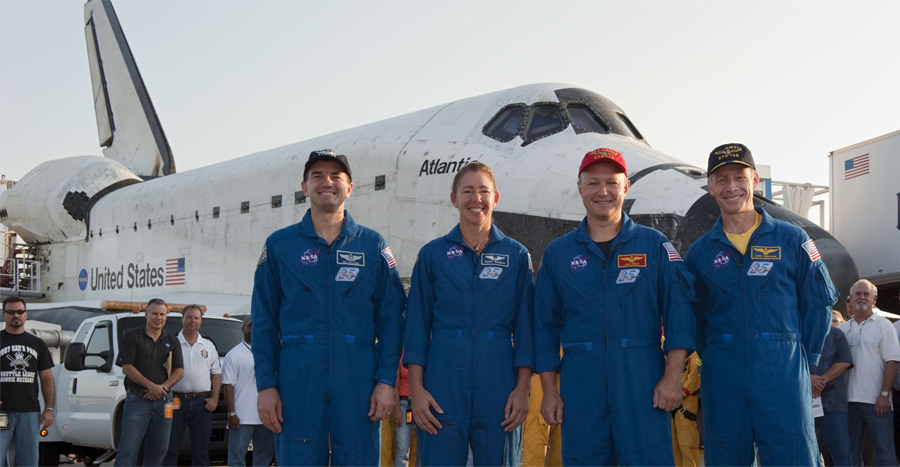 The final space shuttle crew, the astronauts of STS-135, stand with shuttle Atlantis after landing.