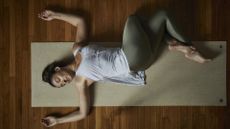 Directly above shot of relaxed young woman doing yoga on exercise mat in studio