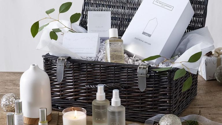 The White Company Calm Hamper in grey wicker basket with products inside and on wooden worktop